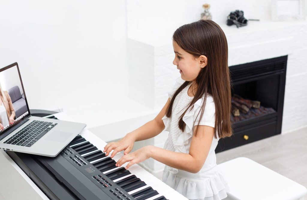 girl learning to play the piano